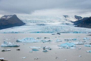 Fjallsárlón glacier melt behind a lagoon with floating icebergs