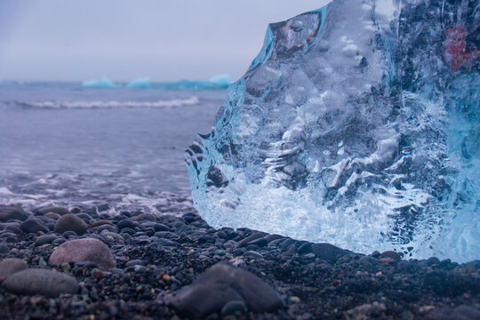 stranded icebergs on a dark pebbly beach in j&ouml;kuls&aacute;rl&oacute;n in iceland