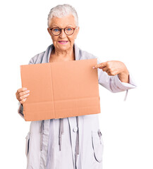 Senior beautiful woman with blue eyes and grey hair holding we need a change banner smiling happy pointing with hand and finger