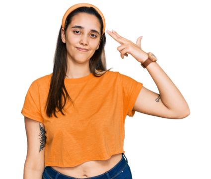 Young hispanic woman wearing casual clothes shooting and killing oneself pointing hand and fingers to head like gun, suicide gesture.