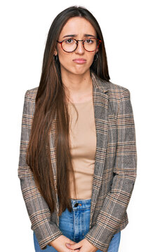 Young hispanic girl wearing business clothes and glasses depressed and worry for distress, crying angry and afraid. sad expression.