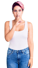 Fototapeta premium Young beautiful woman with pink hair wearing casual clothes asking to be quiet with finger on lips. silence and secret concept.