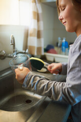 The dishes will be squeaky clean when Im done. Cropped shot of a young girl washing dishes at home.