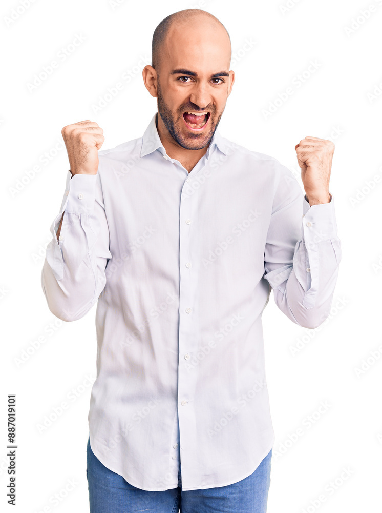 Wall mural Young handsome man wearing elegant shirt screaming proud, celebrating victory and success very excited with raised arms