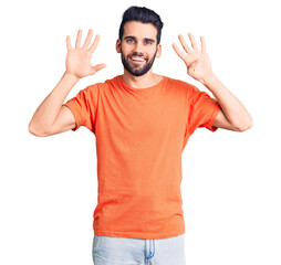 Fototapeta premium Young handsome man with beard wearing casual t-shirt showing and pointing up with fingers number nine while smiling confident and happy.