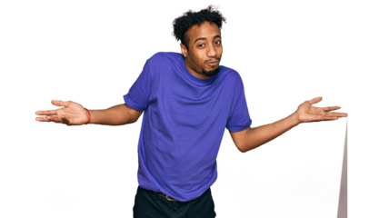 Young african american man with beard wearing casual purple t shirt clueless and confused expression with arms and hands raised. doubt concept.