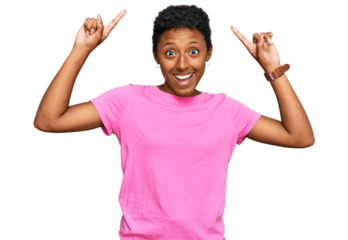 Young african american woman wearing casual clothes smiling amazed and surprised and pointing up with fingers and raised arms.