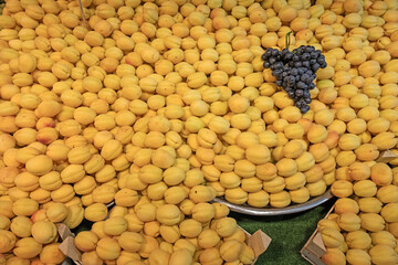 Apricots on the market stall and a bunch of grapes on it.