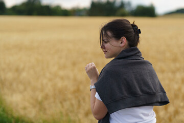 A young smiling beautiful girl with collected hair and a sweater thrown over her shoulders against...