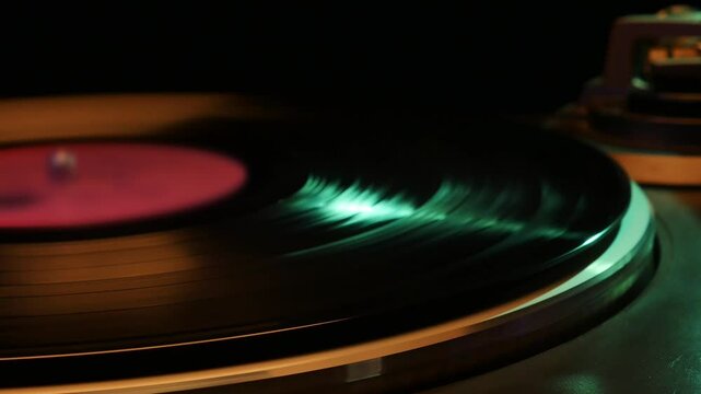 Old analog turntable with vinyl record playing