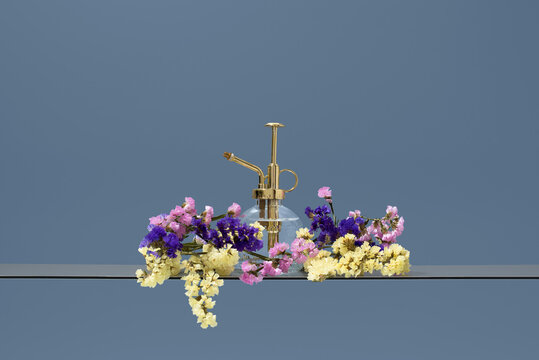 Golden plant mister with colorful Limonium sinuatum setup