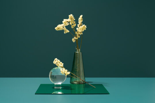 Limonium sinuatum in glass vase on blue background