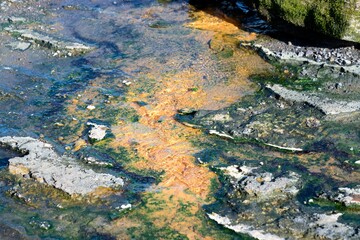 hot water flows from the crack in the colorful rock