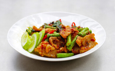 Rice topped with stir fried pork and red curry paste with yard-long bean