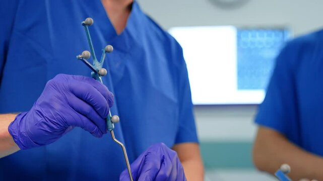 Surgical probe device in the hand of a surgeon. Close up. Doctor moves the tool by the head of the patient.