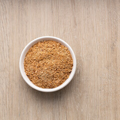 Powdered food based on soy fiber with psyllium fiber to cleanse the colon in the bowl - wooden background