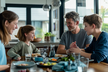 A family of four is sitting at a dining table, enjoying a meal together