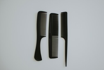 three types of black women's hair combs on a background white background © Alina 