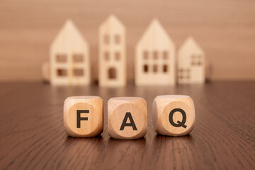 cubes with message FAQ surrounded by wood home. question and answer concept