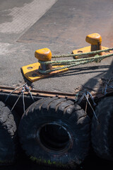 Yellow bollards on the pier. A rope was tied to it.