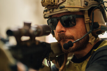 Close up of brave soldier shooting with sniper rifle at battlefield.