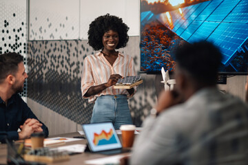 Happy diverse ecologist having presentation with solar panels at office