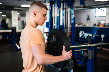 Bodybuilder lifts a weight plate during his workout at the gym
