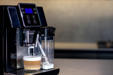Modern coffee machine with glass cup of latte in kitchen