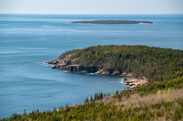Coastal View of Acadia National Park in Spring. A panoramic view of the coastline of Acadia National Park in Maine. The blue ocean stretches out in the distance, with a small island visible in the ba