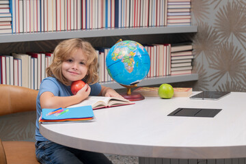 School boy with books and apple in library. Nerd school kid. Clever child from elementary school with book. Smart genius intelligence kid ready to learn. Hard study.