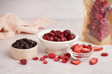 Bowls with tasty freeze-dried fruits on light table