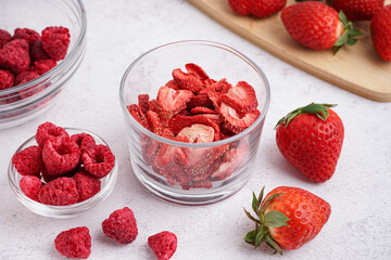Bowls with tasty freeze-dried and fresh berries on light background
