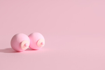 Female breast made of play dough on pink background. Erotic and health care concept
