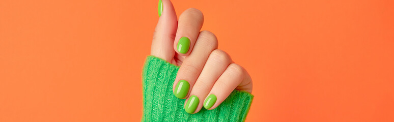 Beautiful womans hands with spring autumn nail design on orange background. Manicure, pedicure beauty salon concept