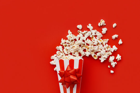 Striped box with popcorn with bow on a red background
