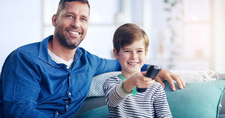 Were going to be couch potatoes today. Shot of a cheerful father and son relaxing on a couch and spending some time together indoors.