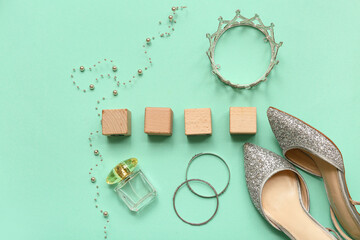 Wooden cubes with prom crown, female shoes and accessories on turquoise background