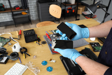 Male technician with mobile phones in service center, closeup
