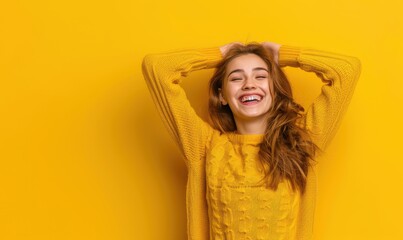 Naklejka premium Happy redhead woman in yellow sweater against yellow background.