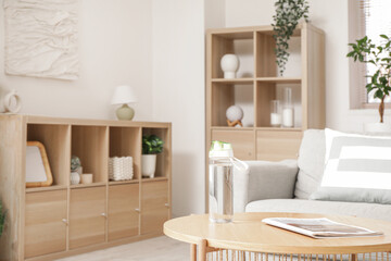 Sports water bottle and magazine on table in living room, closeup