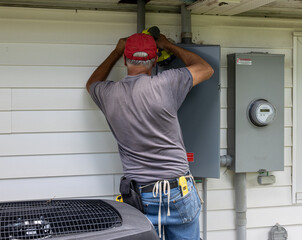 electrician at work drilling into pipe