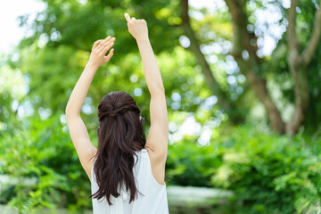 公園でストレッチをする女性の背中