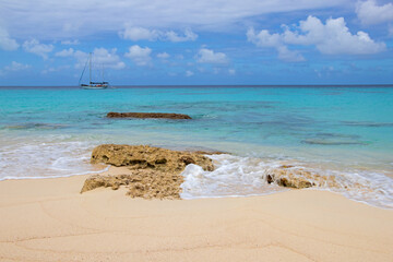 Beautiful rocky beach and sailboat in Grand Turk of the Turks and Caicos