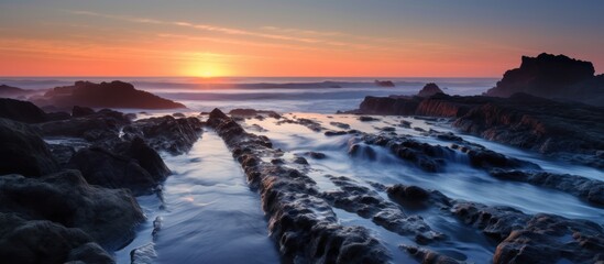Obraz premium Rocky Shoreline at Sunset with Long Exposure