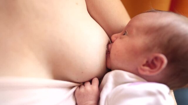 mother breastfeeding newborn. baby newborn a sucks mother breast milk against the background lifestyle of a window indoors. motherhood family kid dream concept. mother breastfeeding newborn