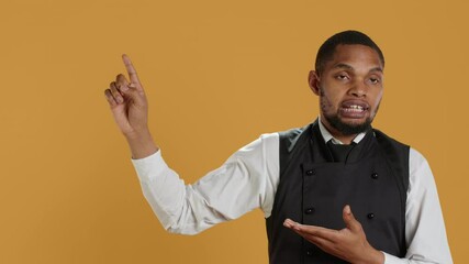 Friendly restaurant staff indicating direction to left or right sides, doing an advertisement for great customer service. Waiter showing professionalism in catering environment. Camera A.