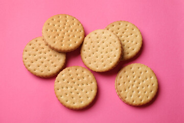 Tasty sandwich cookies on pink background, top view