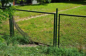 Fototapeta premium Broken school metal mesh fence