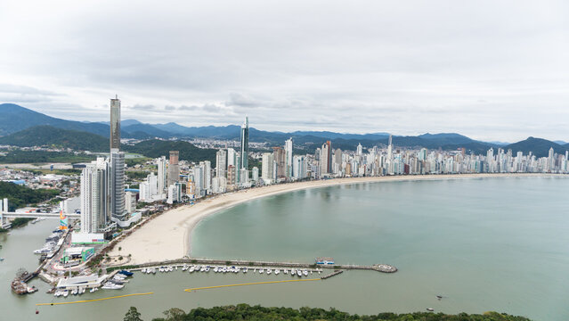 beachfront in Balne&aacute;rio Cambori&uacute;, Santa Catarina, Brazil, seen from above, beach and large building in the background.