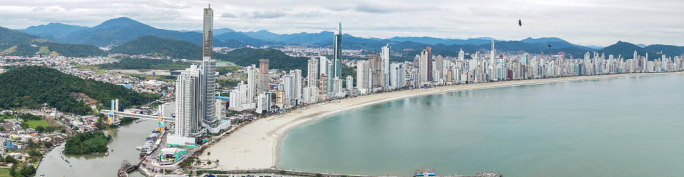 beachfront in Balne&aacute;rio Cambori&uacute;, Santa Catarina, Brazil, seen from above, beach and large building in the background.